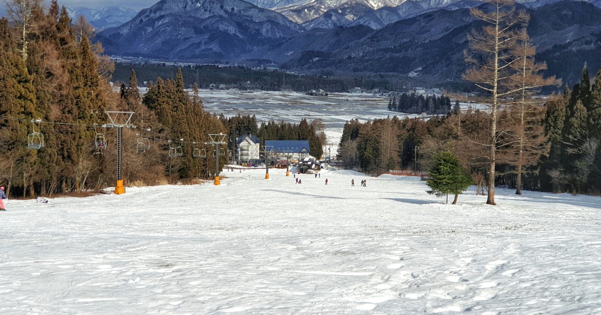 Groomed ski run with a chairlift at Iimori in the Hakuba Valley, looking out over the valley floor to the snow-capped Northern Japan Alps