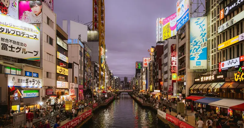 Dotonbori canal in Osaka lined with neon signs at dusk